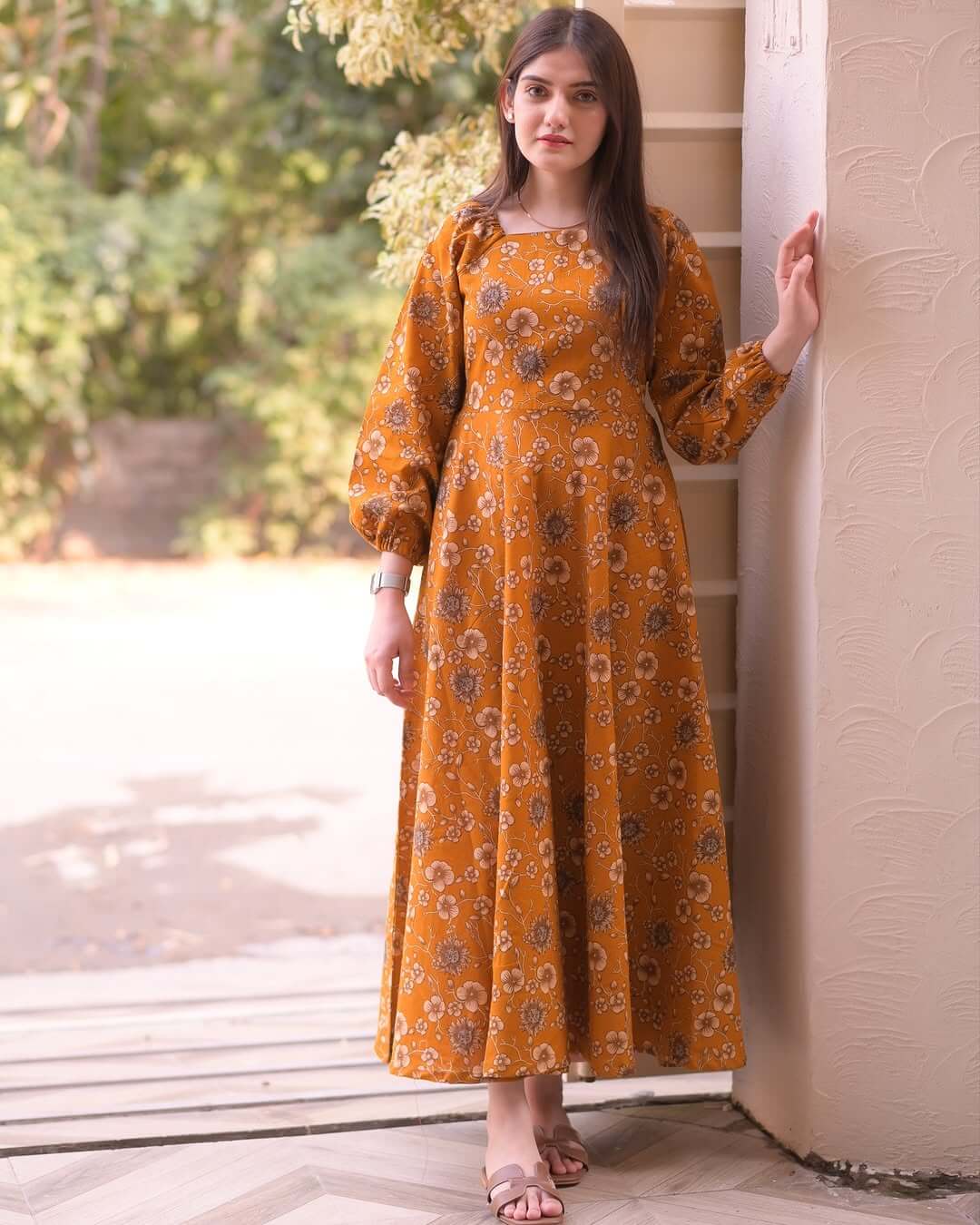 Stylish woman in a lotus print pure cotton midi gown, perfect for summer. Features long sleeves and elegant floral design.